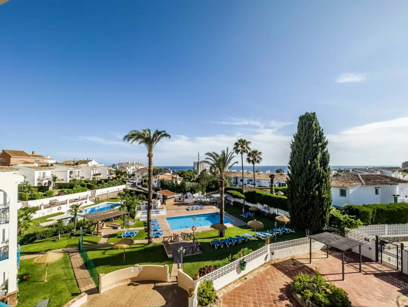 Udsigt over feriekompleks med pool og hav i Mijas i Spanien